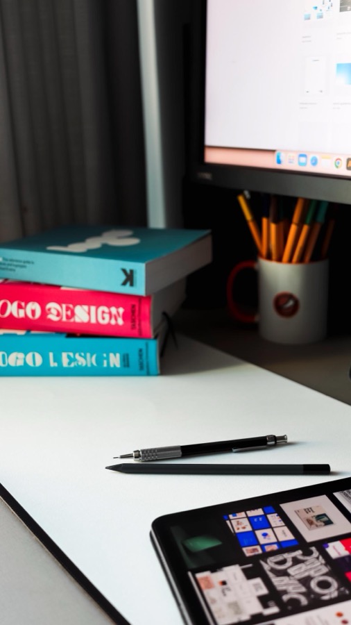 Kreativer Arbeitsplatz mit Designbüchern und Tablet