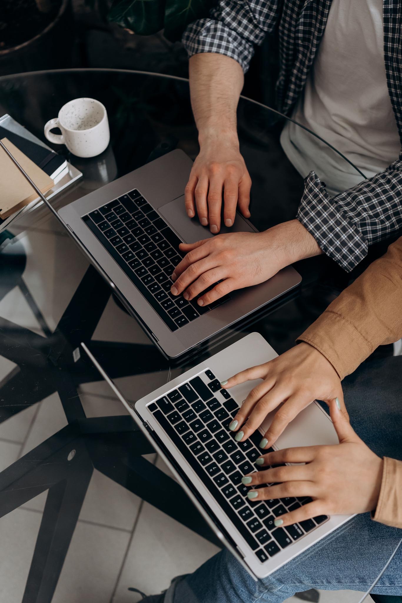 Zwei Personen arbeiten gemeinsam an Laptops